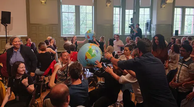 The audience throws an inflatable globe to each other.
