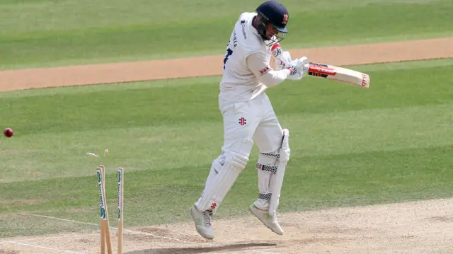 Simon Harmer of Essex chops a Matthew Fisher delivery on to his stumps