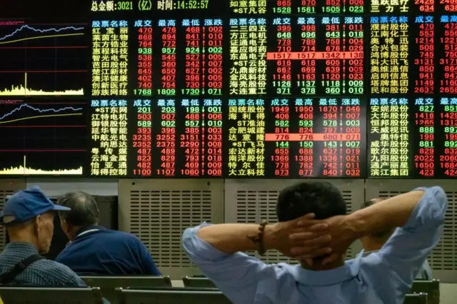 Investors watch the electronic board at a stock exchange hall on June 20, 2019 in Shanghai, China.