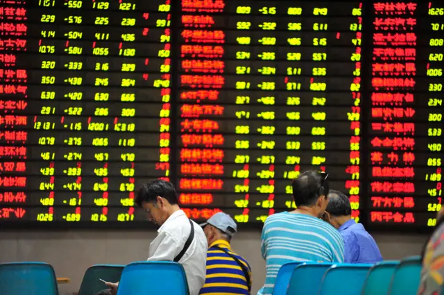 Investors watch an electronic ticker board displaying stock figures at a stock exchange hall on July 8, 2019 in Nanjing, Jiangsu Province of China.