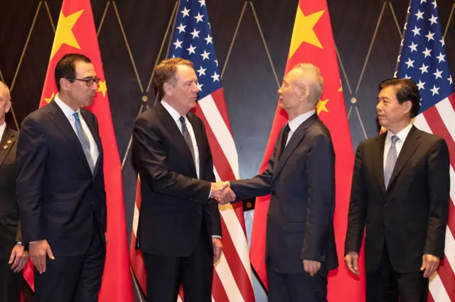 United States Trade Representative Robert Lighthizer (2L) shakes hands with China's Vice Premier Liu He (2R) as US Treasury Secretary Steven Mnuchin (L) and China's Commerce Minister Zhong Shan (R) at the Xijiao Conference Center in Shanghai on July 31, 2019.