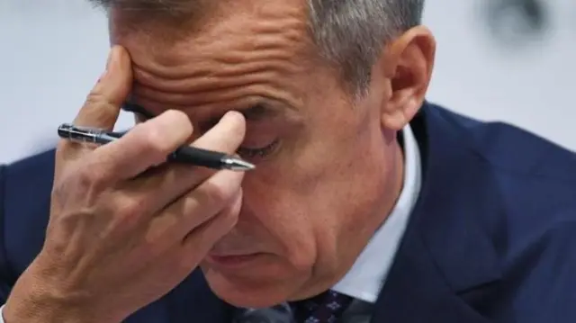 mark Carney with a pen in his hand