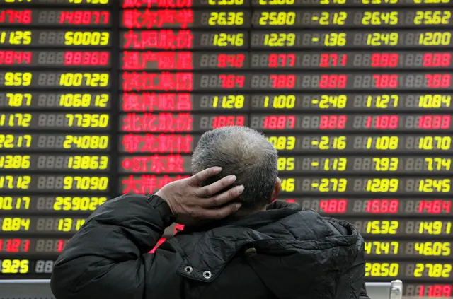 Man looks at stock boards in China