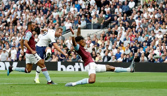 Tyrone Mings blocks a shot from Harry Kane