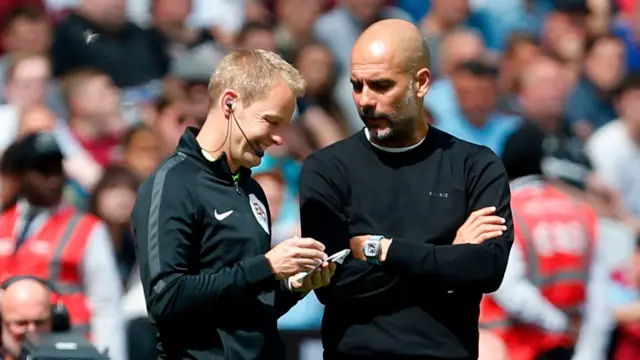 Pep Guardiola in discussion with the fourth official