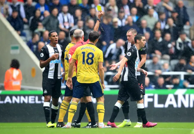 Newcastle United's Miguel Almiron receives a yellow card