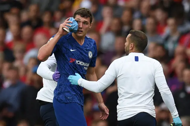 Andreas Christensen applies an ice pack to his cheek