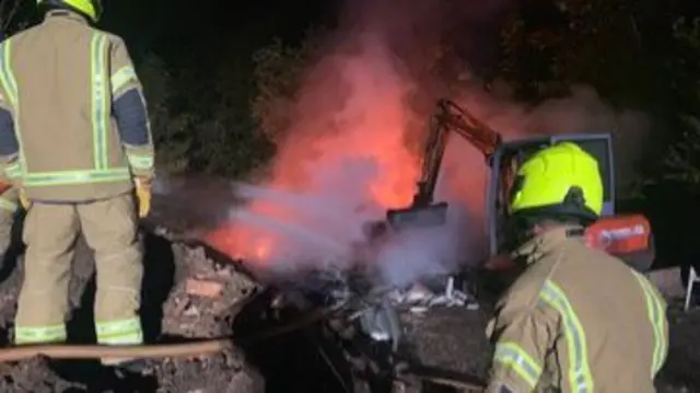 Digger being used to fight fire