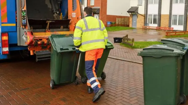 Generic of bin man taking away waste