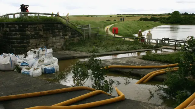 Firefighters and engineers pump water out of the Ulley Reservoir near Rotherham