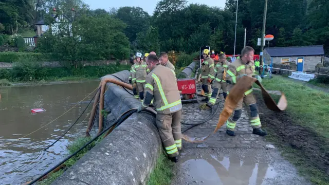 Firefighters with water pump