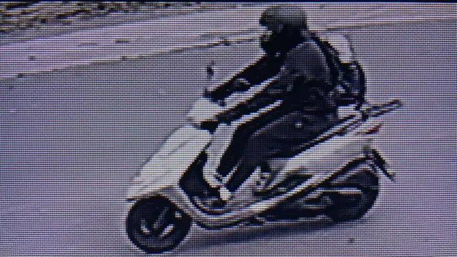 A CCTV image of a person on a scooter