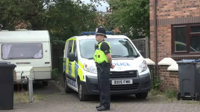 Police officer outside house