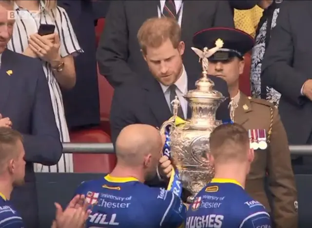 Prince Harry hands over the Challenge Cup trophy