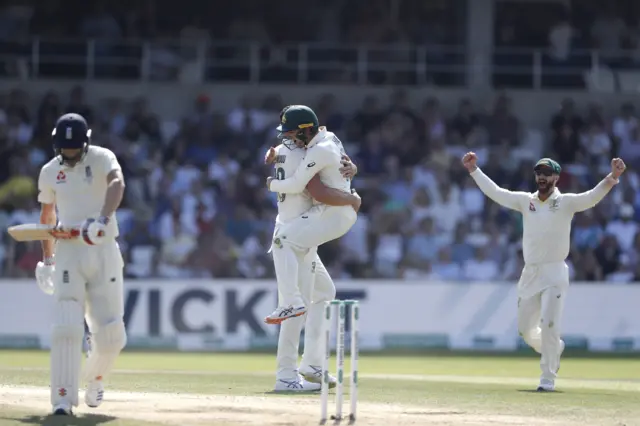 Josh Hazlewood of Australia celebrates with Travis Head and Matthew Wade of Australia after taking the wicket of Chris Woakes