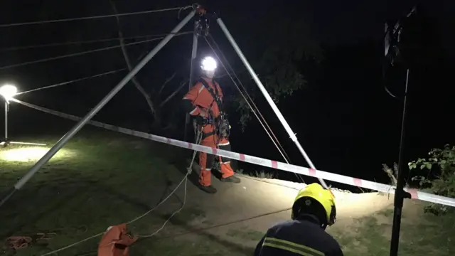 Firefighter being winched over edge of drop