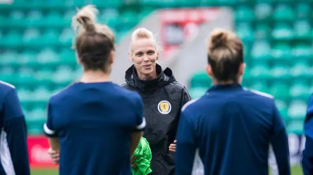 Head coach Kerr talks to players ahead of the game at Easter Road