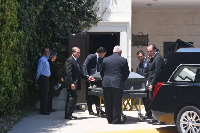 Funeral services staff and relatives receive the body of teacher Elsa Mendoza, one of the victims of El Paso shooting, in Ciudad Juarez, Mexico