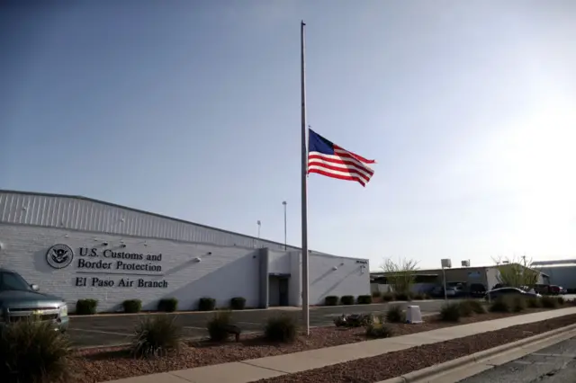 The American flag flies at half-staff at a U.S. Customs and Border Protection office not far from the scene of a mass shooting