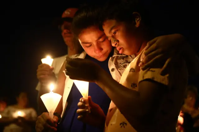 People attend a candlelight prayer vigil outside Immanuel Baptist Church, located near the scene of a mass shooting which left at least 22 people dead, on August 5, 2019 in El Paso