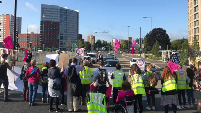 From behind protesters as they block road