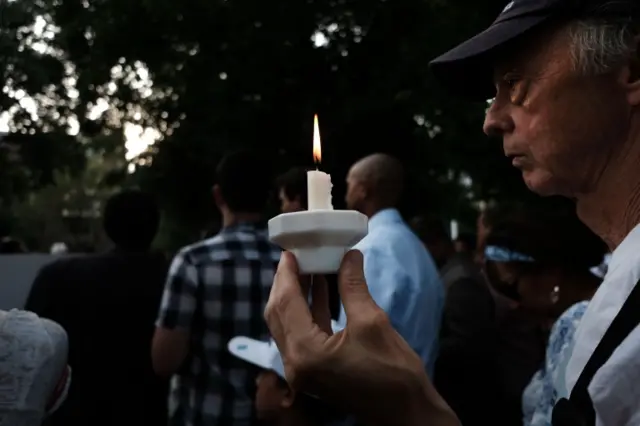 Mourners in New York City hold candles