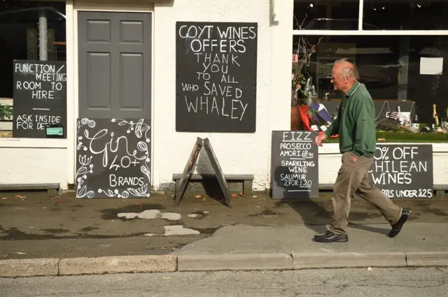 Man walks past thank you pub sign