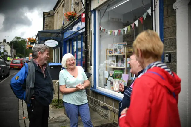 Resdients catch up outside shop