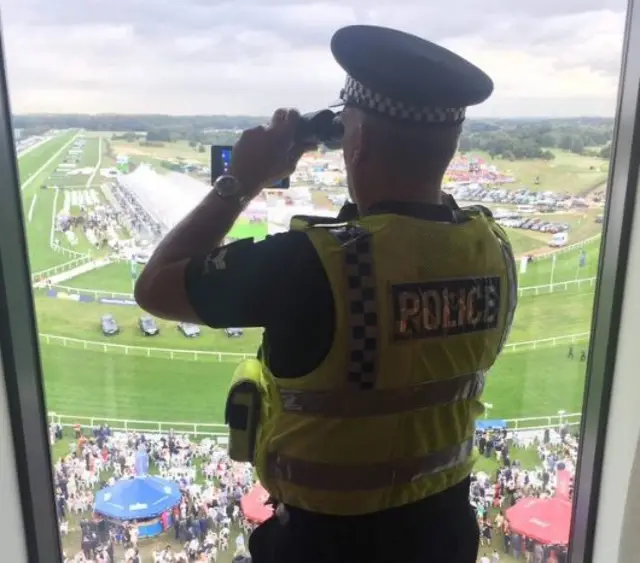 Policeman with binoculars at racecourse