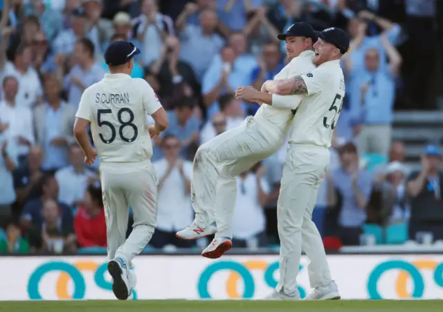 England's Rory Burns celebrates with teammates Sam Curran and Ben Stokes after taking a catch to dismiss Australia's Peter Siddl