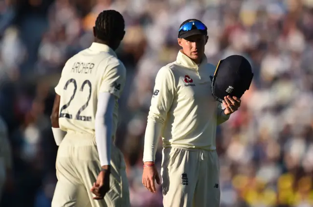 England's captain Joe Root (R) talks to England"s Jofra Archer during play on the second day of the fifth Ashes cricket Test match between England and Australia at The Oval