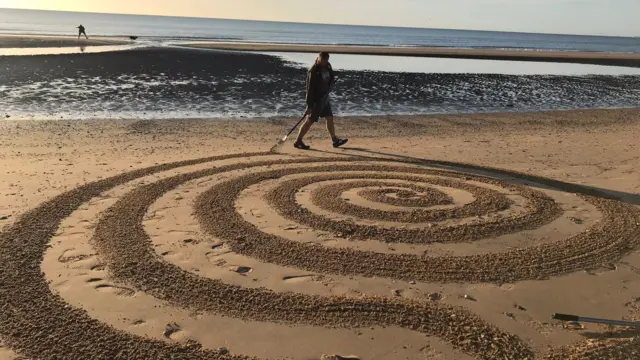 A person doing a sand pattern