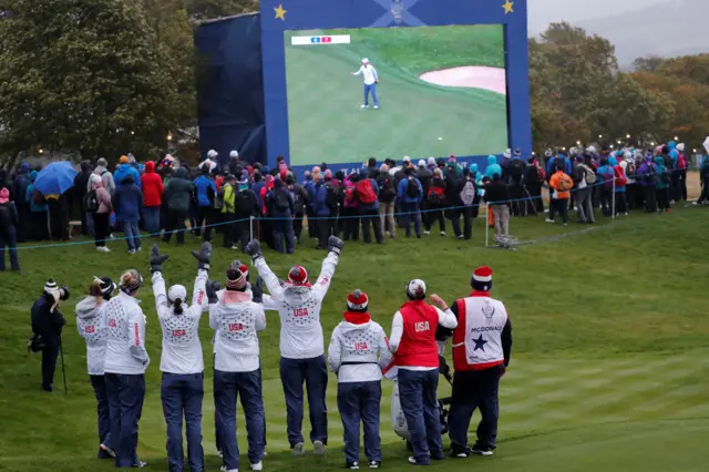 The US team support Danielle Kang as putts out on 17 to win a point