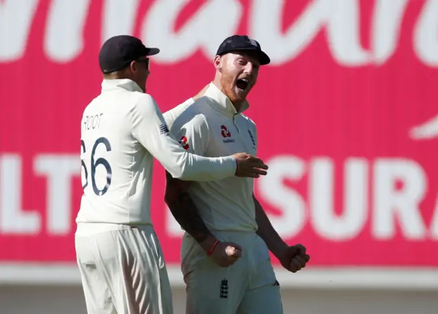 England's Ben Stokes celebrates with teammate Joe Root after taking a catch to dismiss Australia's Steve Smith