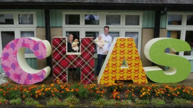 Family with CHAS sign