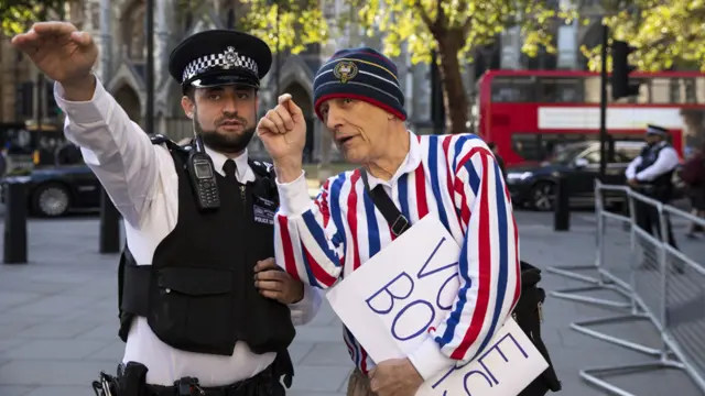 A protester in support of Boris Johnson is directed as to where he can stand outside The Supreme Court