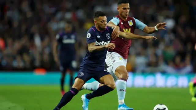 Neil Taylor of Aston Villa (right) defending against West Ham