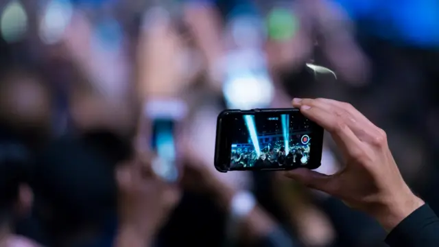 A person films on a smartphone