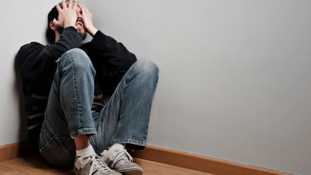 Sad man with depression sitting on the floor