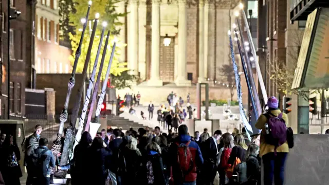 Harry Potter fans gather at an installation of giant wands set between St Paul's Cathedral and the Millennium Bridge.