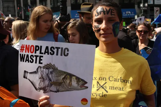 Girl with sign about plastic waster