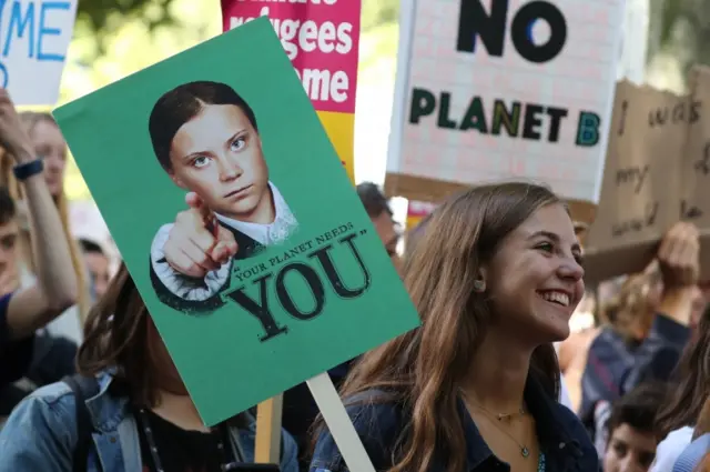 Sign has a photo of Greta Thunberg pointing at the viewer, saying "your planet needs YOU"