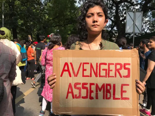 Protester in Delhi with sign saying Avengers Assemble