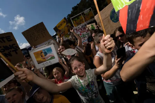 Young protesters hold placards saying "SOS" at a rally in Sydney