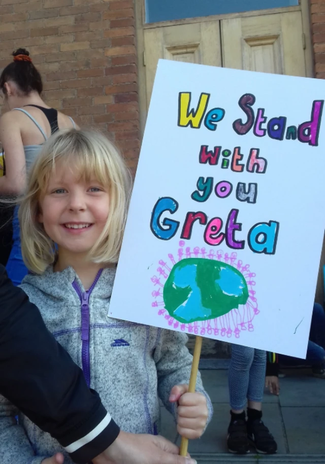 Young person holding banner