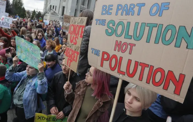 Protesters in Kiev, Ukraine, holding signs saying "Be part of the solution not the pollution"