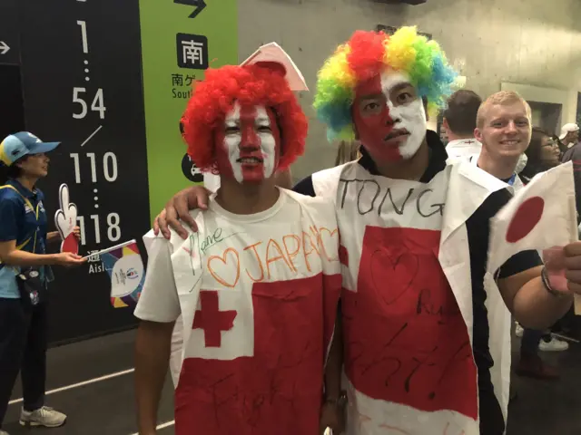 Two Tonga supporters with rainbow wigs