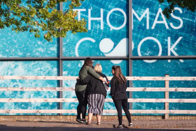 People stand outside Thomas Cook's Peterborough headquarters