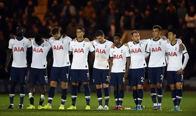 Tottenham players look down as they link arms during the penalty shootout