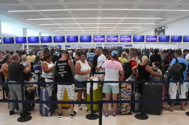 Thomas Cook customers queue at the airport in Cancun, Mexico